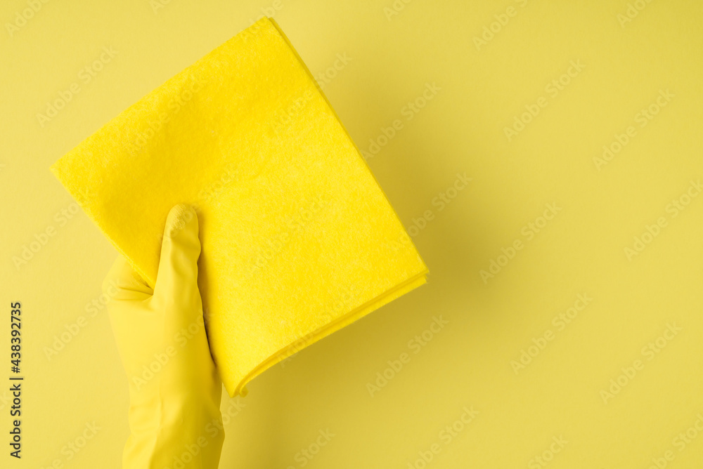 Above pov photo of cleaning rag and yellow gloves isolated on the yellow background Above pov photo of cleaning rag and yellow gloves isolated on the yellow background