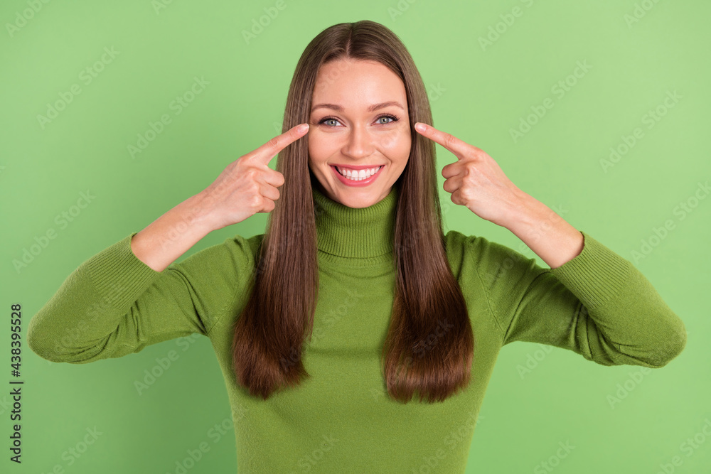Photo of charming happy positive lady point finger eyes good mood eyesight isolated on green color background Photo of charming happy positive lady point finger eyes good mood eyesight isolated on green color background