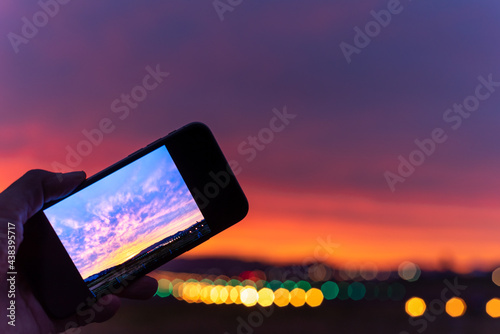 夕焼けを撮影するスマートフォンのイメージ 