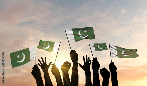 Tableau sur toile Silhouette of arms raised waving a Pakistan flag with pride
