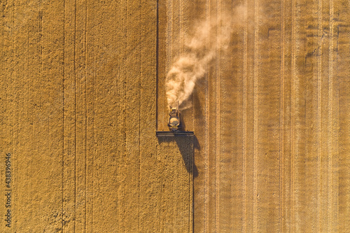 Bird's eye view of a header harvesting a barley crop in the late afternoon.