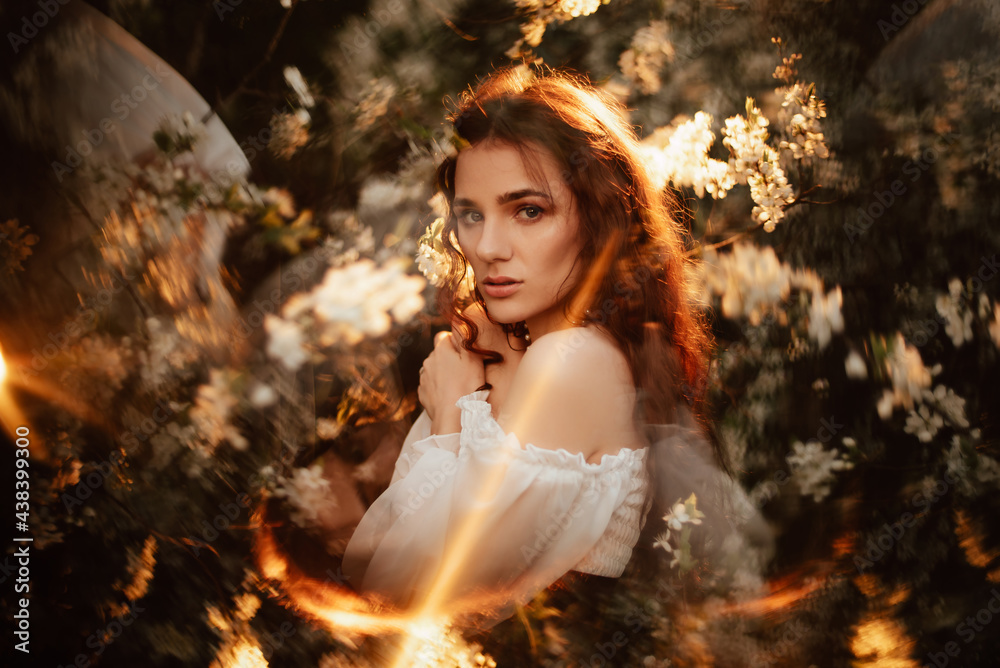 Portrait of a romantic girl, like a forest fairy, in a blooming garden with elements of phantasmagoria. The concept of fantasy, fairy tales.