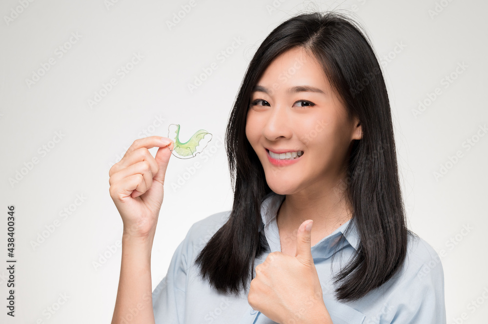 Asian woman holding orthodontic retainers.Teeth retaining tools after braces ... Asian woman holding orthodontic retainers.Teeth retaining tools after braces ...