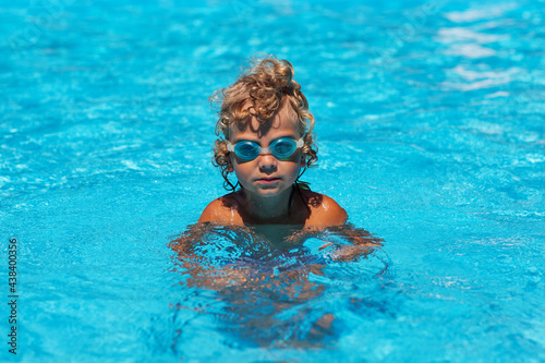 Curly boy in the pool with glasses © Maygutyak