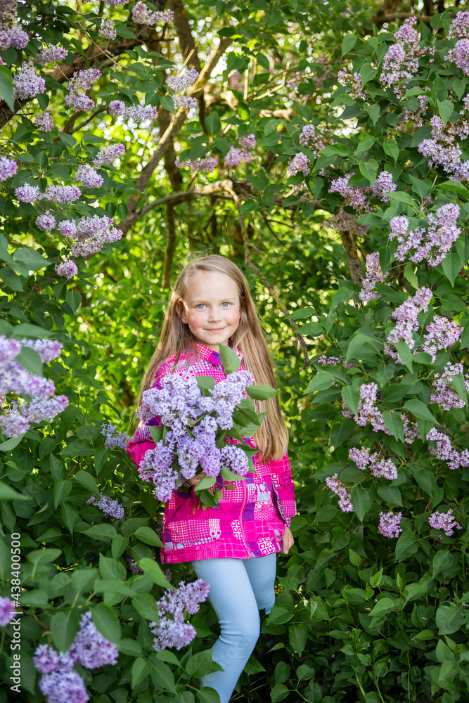beautiful girl with long hair rejoices in spring. Lilac. May