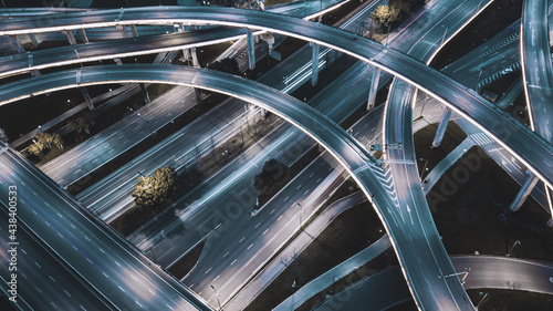 Night long exposure illumination of elevated multilevel traffic junction. Modern development of backlighted roads and current new infrastructure in China, Chengdu. Aerial drone point of view.