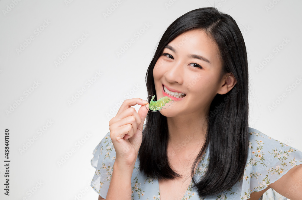 Asian woman holding orthodontic retainers.Teeth retaining tools after braces ... Asian woman holding orthodontic retainers.Teeth retaining tools after braces ...