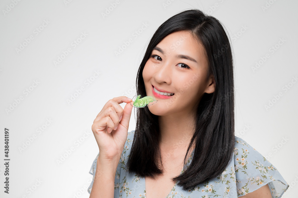 Asian woman holding orthodontic retainers.Teeth retaining tools after braces ... Asian woman holding orthodontic retainers.Teeth retaining tools after braces ...