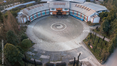 Aerial drone top down view of round circle square near school monastery with Yin and yang sign in middle. Cinematic colors place for meditation and practicing Asian martial arts. Empty space no people