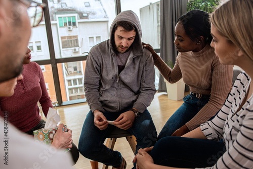Quadro su tela Diverse group of people sitting in circle in group therapy session