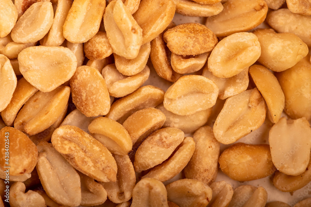 Roasted salted peanuts, surface texture. Close-up, selective focus. Roasted salted peanuts, surface texture. Close-up, selective focus.
