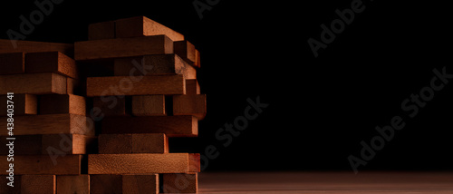 Wooden blocks stacked alternately on a table against a black background. The concept of starting a strong corporate foundation for business growth.