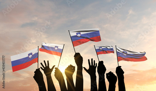 Silhouette of arms raised waving a Slovenia flag with pride. 3D Rendering photo