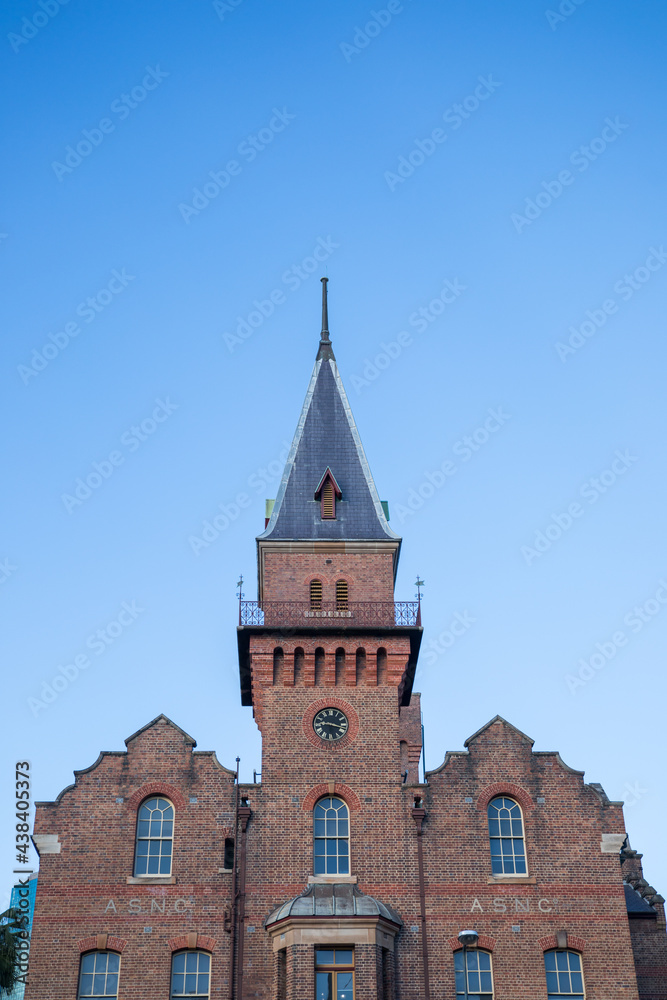 Fototapeta premium Looking up at old tower against blue sky