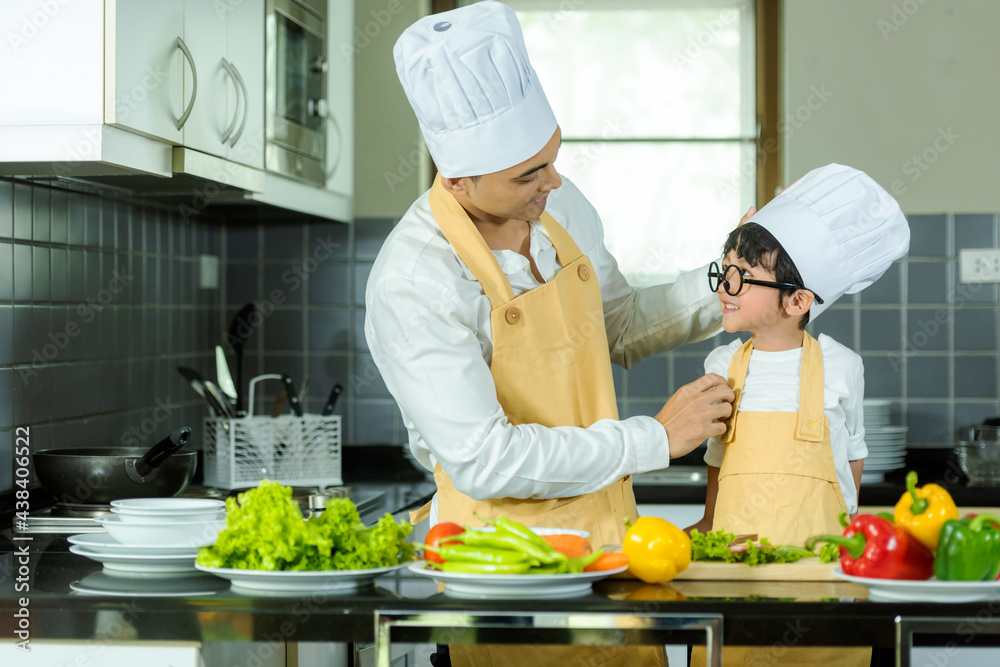 Cooking Family. Chef parent and kid boy make fresh vegetables salad for healthy eat. Asian son helping make food, so happy and enjoy Cooking Family. Chef parent and kid boy make fresh vegetables salad for healthy eat. Asian son helping make food, so happy and enjoy