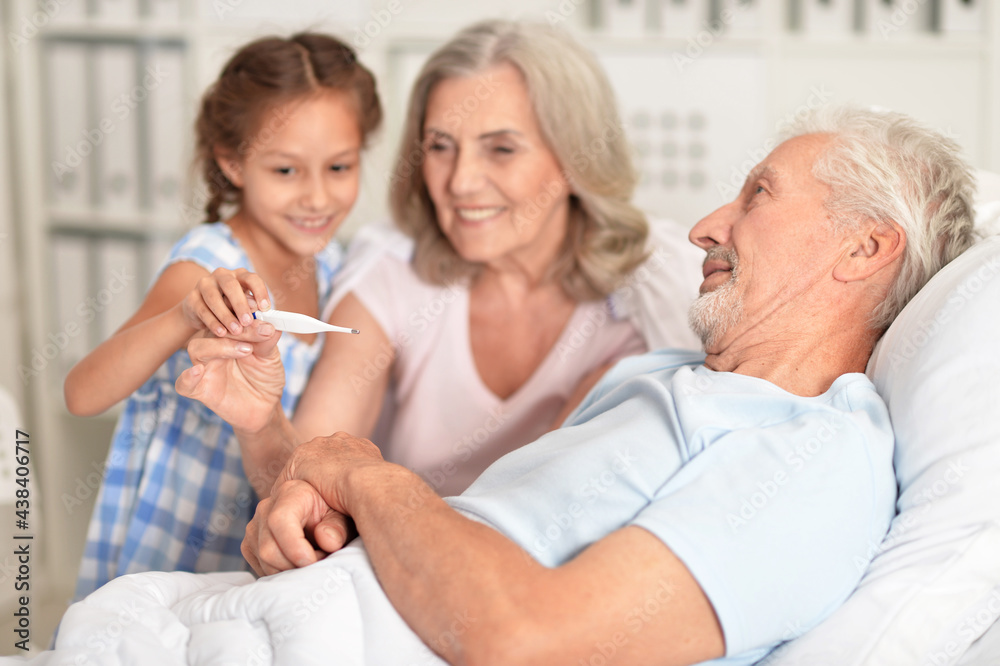 Granddaughter taking temperature of ill grandfather Granddaughter taking temperature of ill grandfather