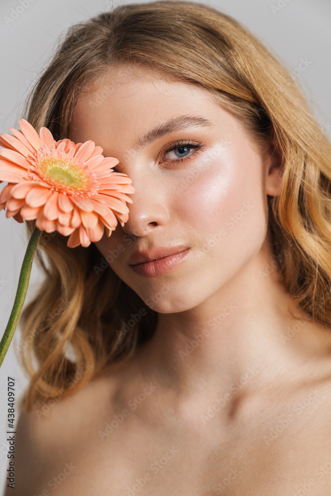 Half-naked ginger woman posing with gerbera flower