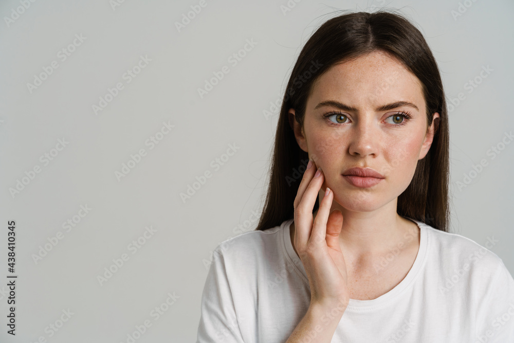 Young white woman with toothache touching her cheek Young white woman with toothache touching her cheek