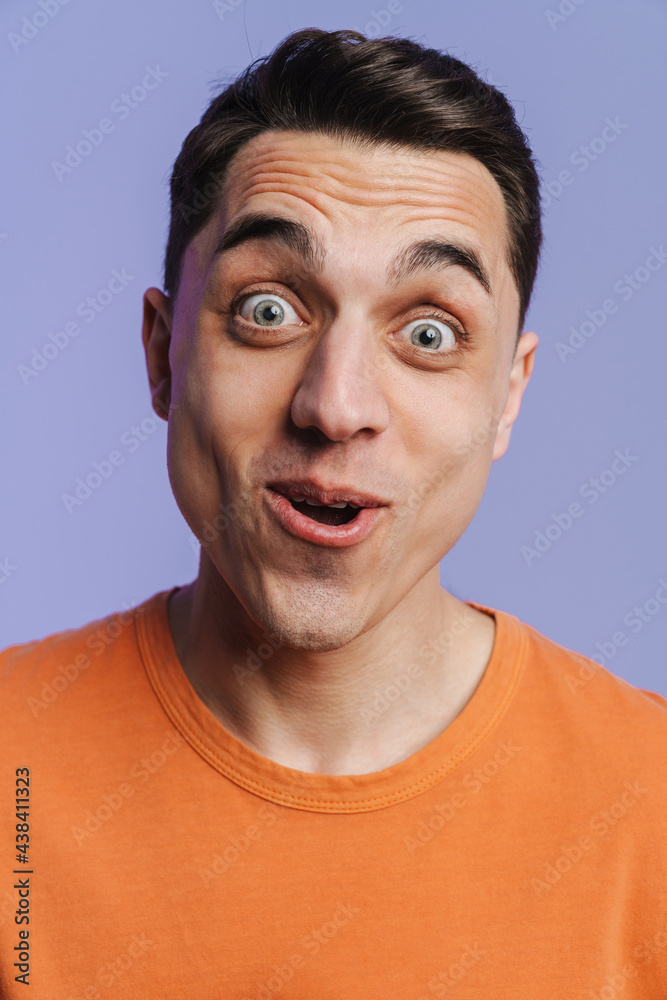 Young brunette white man expressing surprise at camera