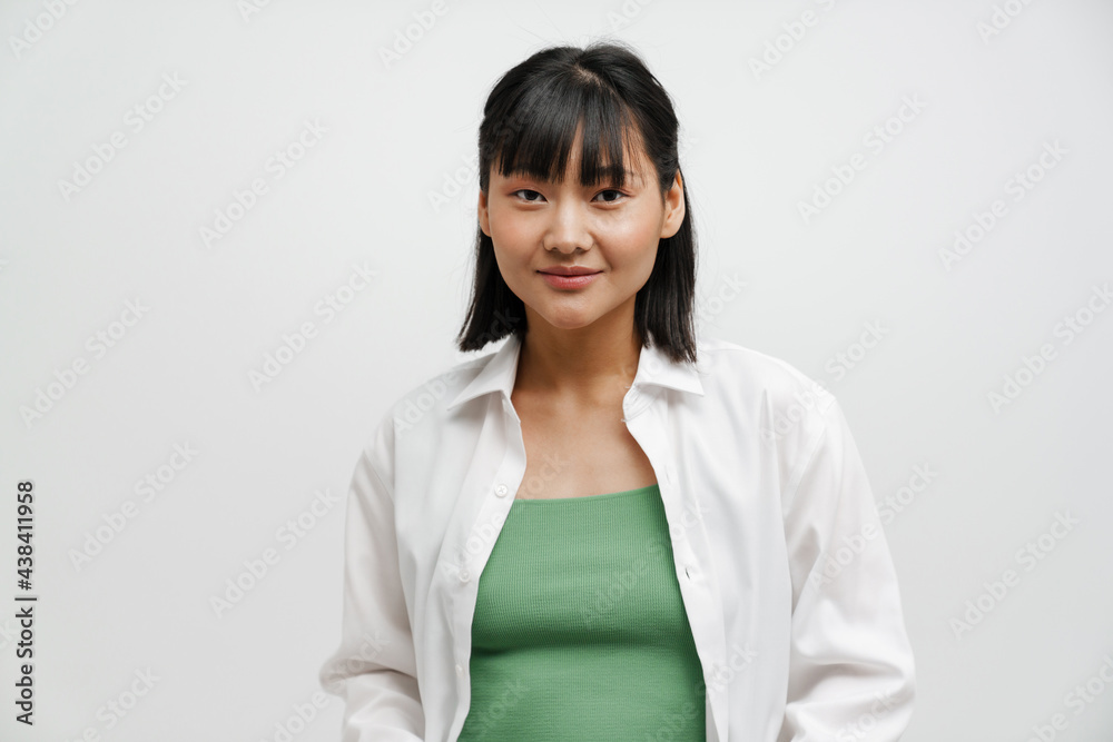 Young asian woman wearing shirt smiling and looking at camera Young asian woman wearing shirt smiling and looking at camera