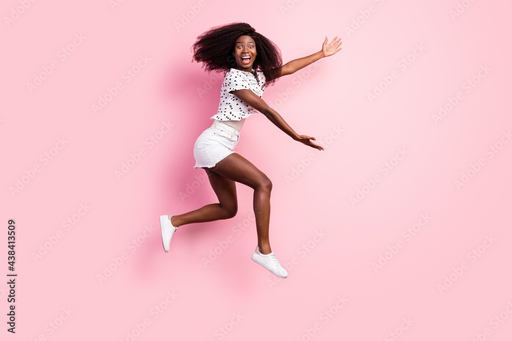 Full body profile side photo of brunette dark skin lady jump up air show hands empty space isolated on pink color background Full body profile side photo of brunette dark skin lady jump up air show hands empty space isolated on pink color background
