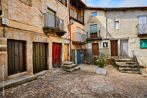 Courtyard with several coloured wooden doors and different constructions in Miranda Del Castañar, Salamanca