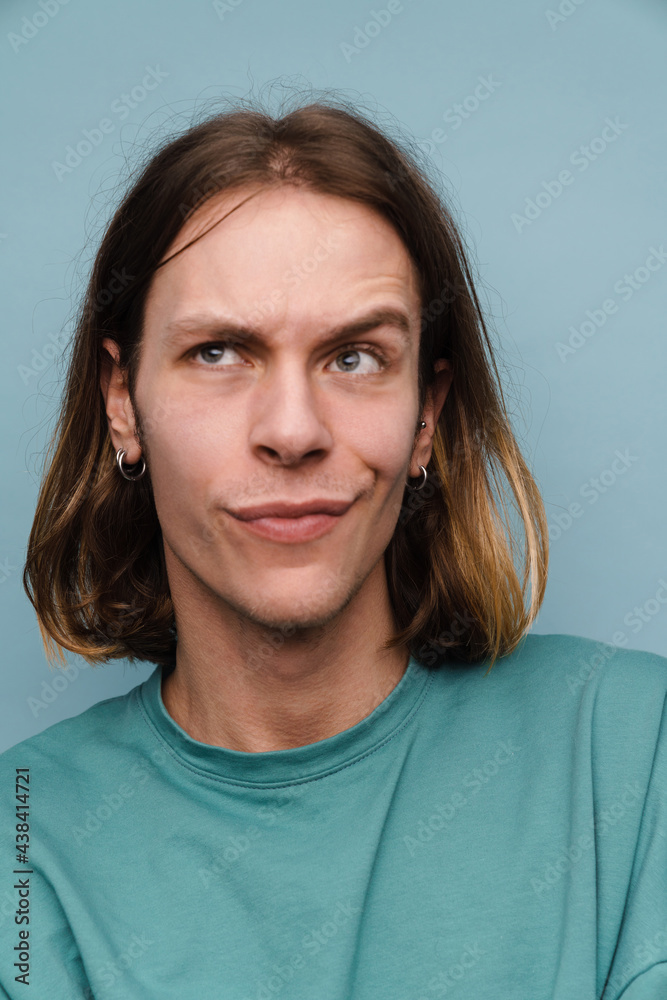Young white man wearing t-shirt frowning while looking upward Young white man wearing t-shirt frowning while looking upward