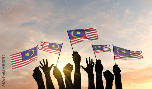 Silhouette of arms raised waving a Malaysia flag with pride. 3D Rendering photo
