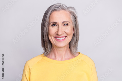 Photo of shiny adorable mature lady wear yellow clothes smiling isolated grey color background