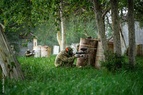 People in uniforms with guns play paintball photo