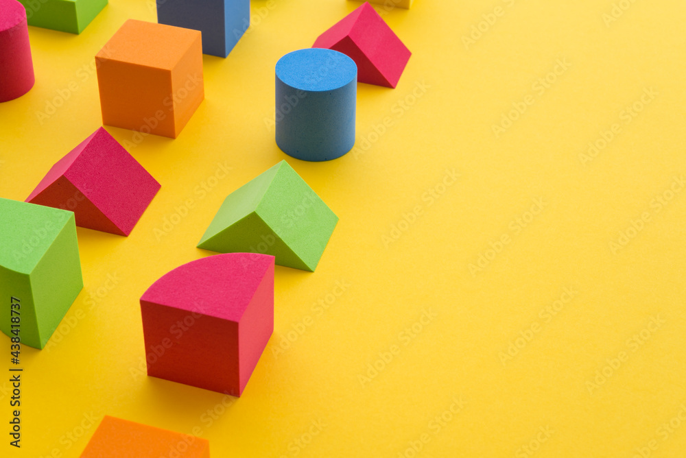 Obraz premium Set of colorful geometric cube or block toy on yellow background. Abstract pattern design composition by shape and form. Education, business solution and creative design product concept.