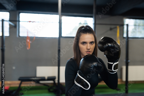 a woman boxer in gloves and sexy sportswear trains in a modern gym © Minet