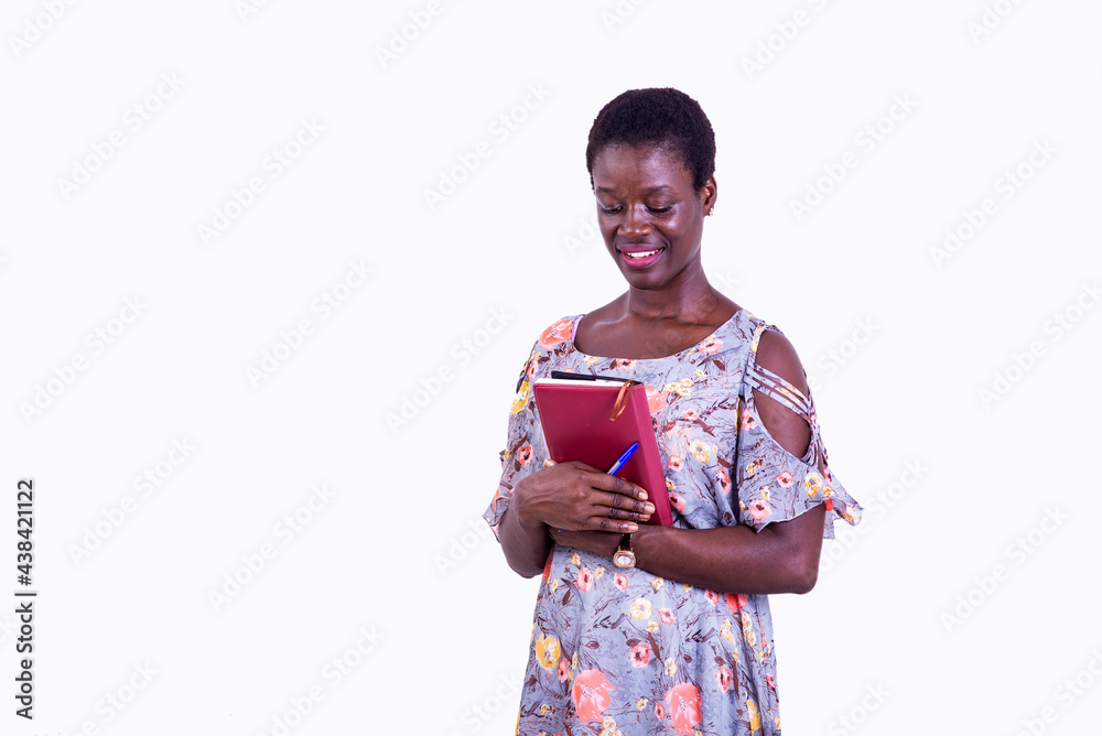 beautiful young female student holding a book smiling. beautiful young female student holding a book smiling.
