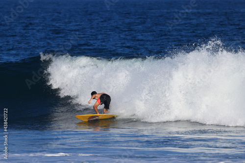 Surfers ride the waves in Bali, Indonesia during summer vacation