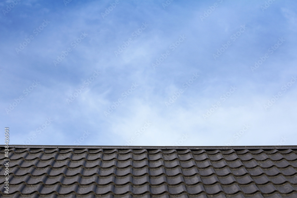 metal roof against a blue sky with clouds. protection of real estate metal roof against a blue sky with clouds. protection of real estate