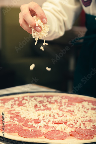 Preparing pizza for baking in the oven.