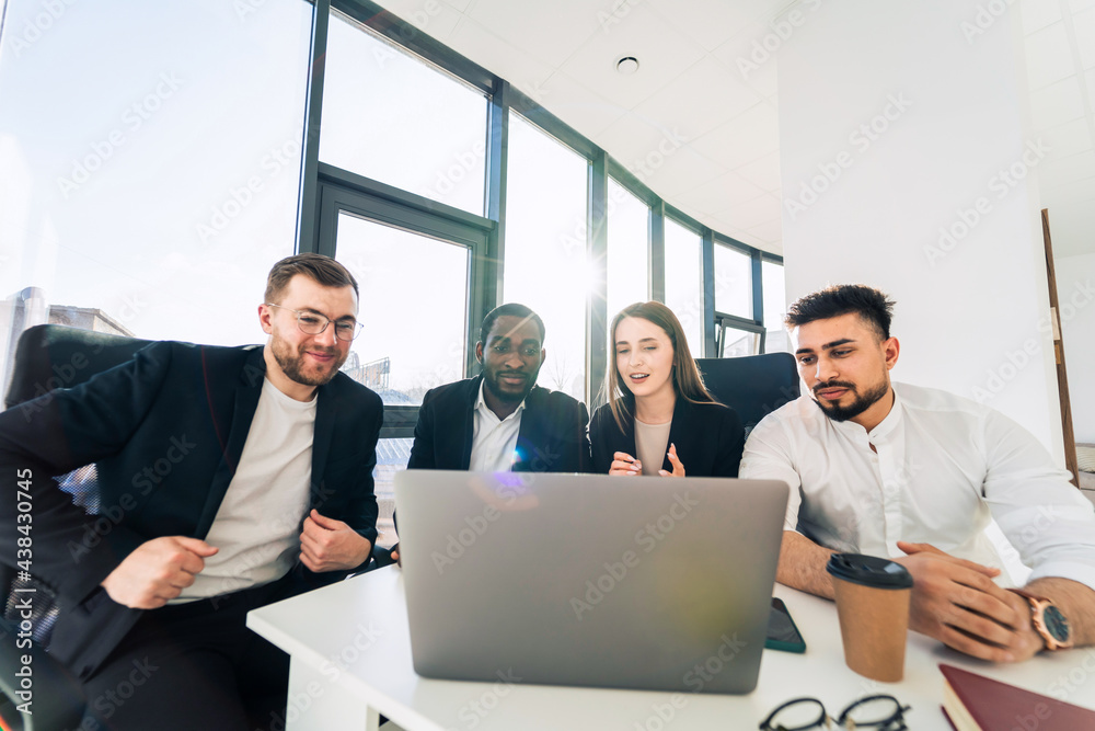 Employees of financial corporation watch the growth of their company's shares on a laptop