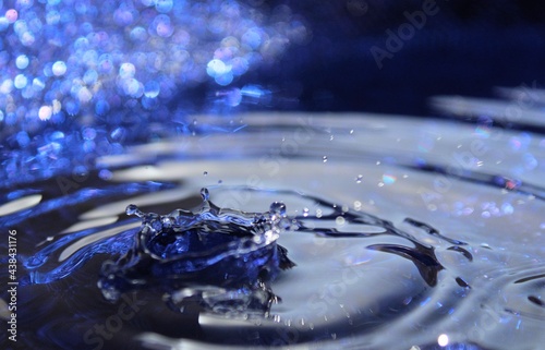 Wallpapers. Frozen movement of water. Drops of water falling and splashing. Sparkles, reflections of light. Intense blue color. 