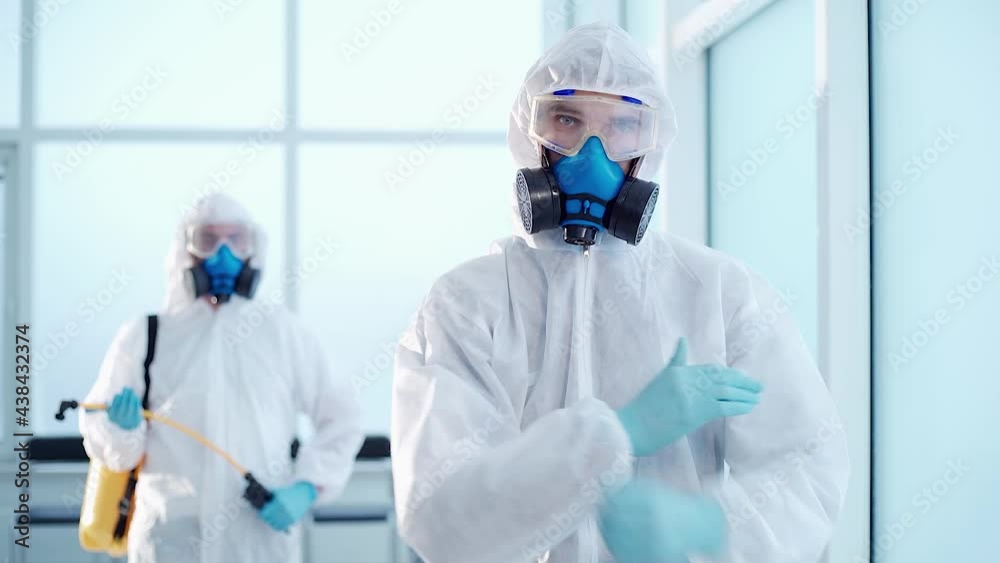 disinfector in a biohazard suit showing a thumbs up. disinfector in a biohazard suit showing a thumbs up.