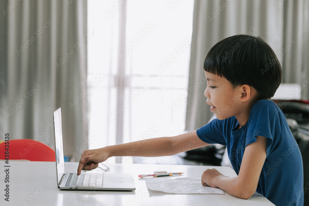 Asian boy logging in online class with laptop to study.