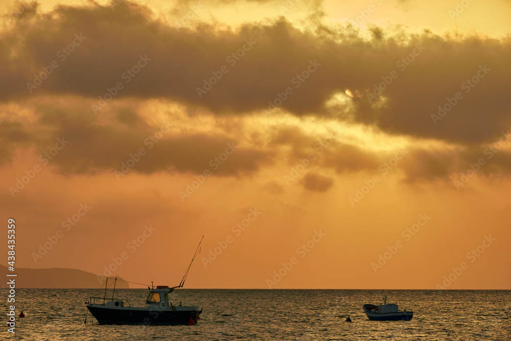 sunset over the sea of the Egadi islands in with silhouettes of boats sunset over the sea of the Egadi islands in with silhouettes of boats
