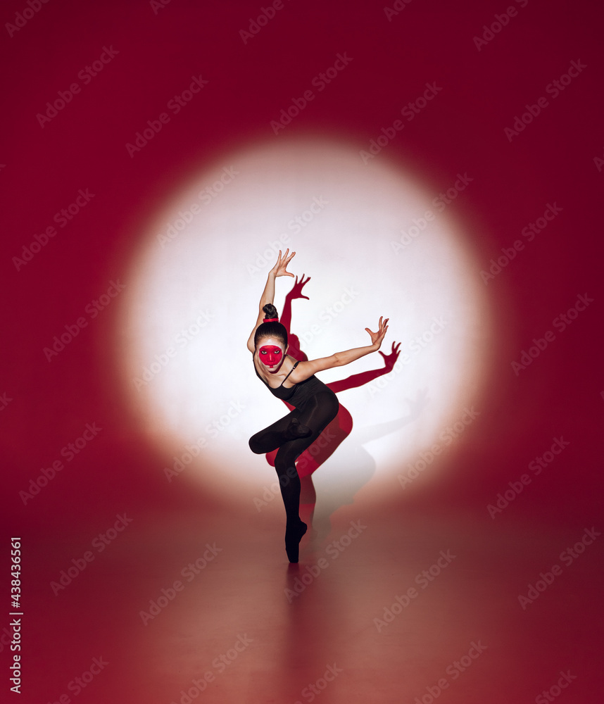 Ballet dancer dancing over red studio background. Modern design. Contemporary colorful conceptual light as rising sun at Japan.