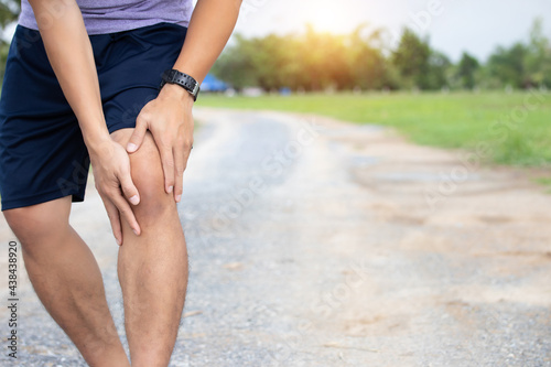 Male athlete runner knee injury and pain after jogging. Athlete man runner touching knee in painful.