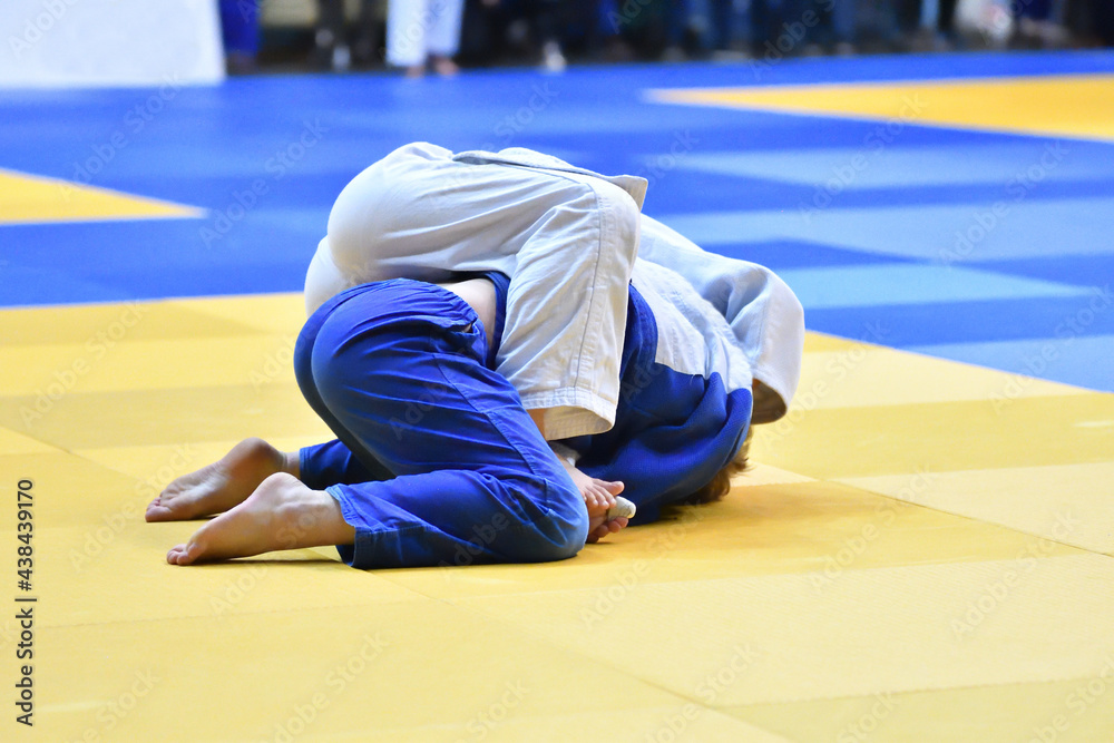 Two Girls judoka in kimono compete on the tatami Two Girls judoka in kimono compete on the tatami