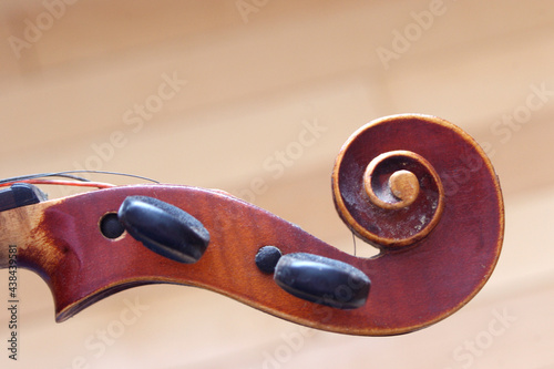 vintage brown violin head music instrument close up on light brown background  photo