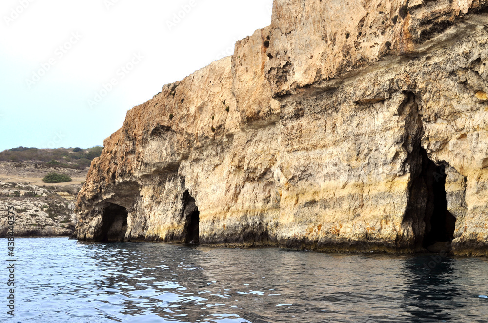 A picture of a sea caves used from the smuglars in the past, taken by a boat along the rocky coast of Malta, Europa.