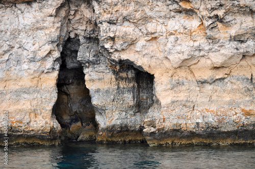 A picture of a sea caves used from the smuglars in the past, taken by a boat along the rocky coast of Malta, Europa.