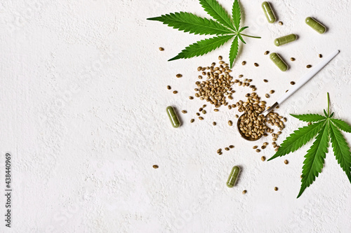 Cannabis medicine capsules, hemp green leaves and seeds on white background. Anesthesia and sedative effect cannabis concept