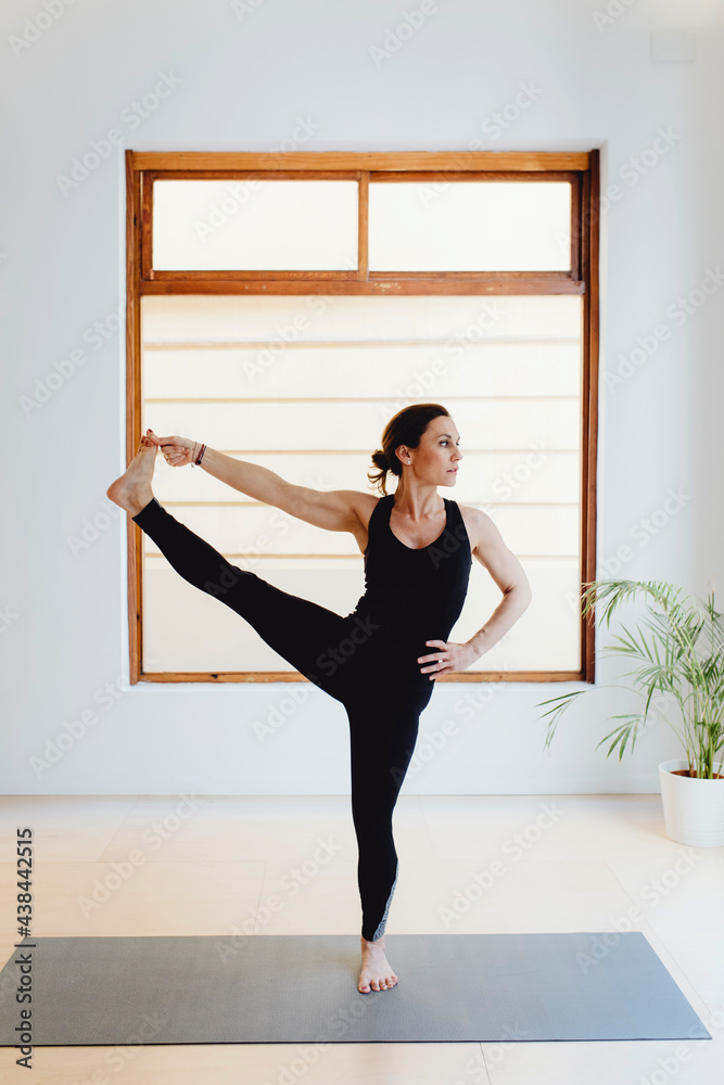 Woman practicing yoga in training room Woman practicing yoga in training room