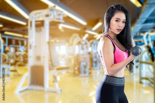 Fitness Asian Portrait of women performing doing exercises training with dumbbell sport in sport gym interior and fitness health club with sports exercise equipment background.